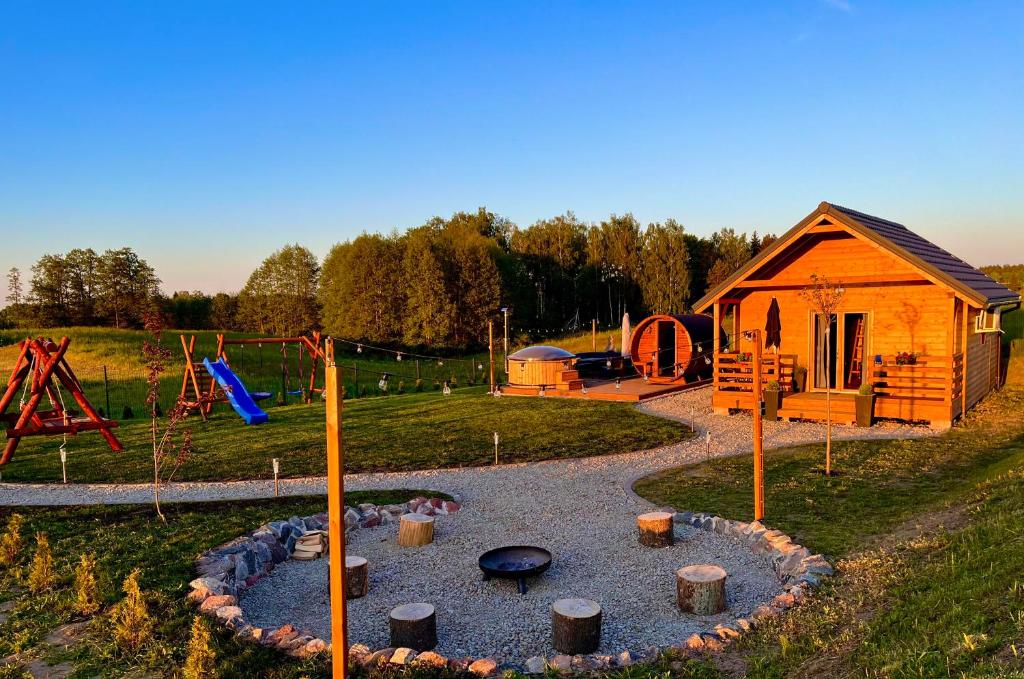 a playground with a small house at Dębowy Domek Mazury in Szczybały Giżyckie