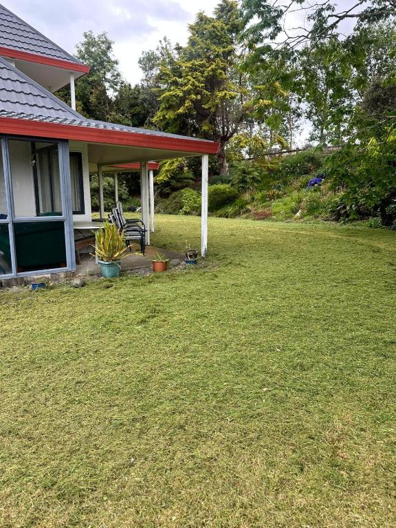 a house with a lawn in front of it at RUs Terraces in Kauri