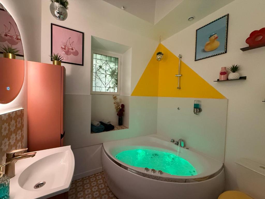 une salle de bain avec une baignoire et un lavabo dans l'établissement Relais Cocorico - Cocon proche tour Eiffel avec baignoire Balnéo, à Paris
