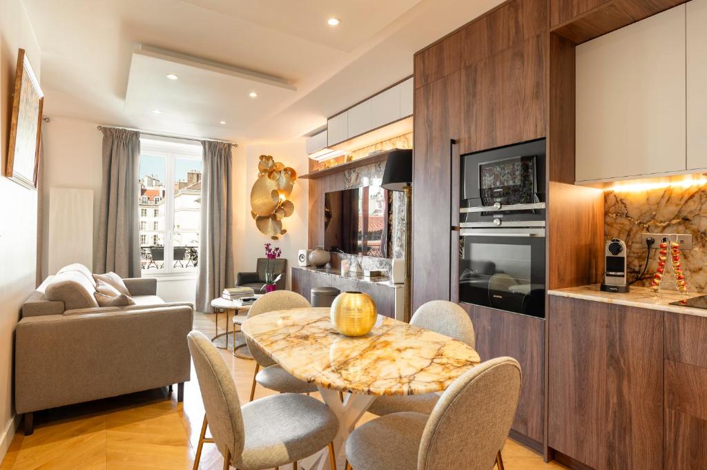 une cuisine et un salon avec une table et des chaises dans l'établissement SaintGermainByCecile - Luxueux 2 pièces AC Ambre, à Paris