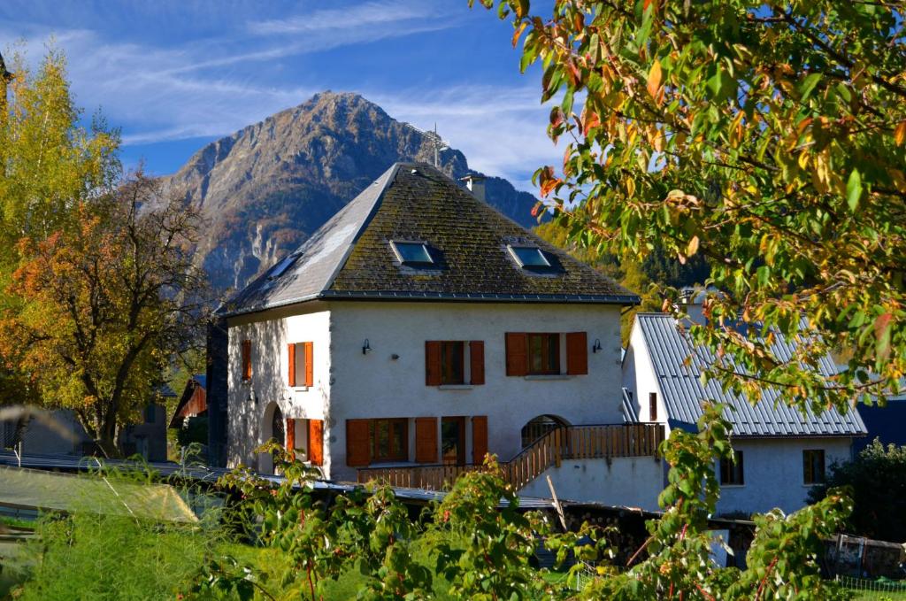 ein weißes Haus mit einem Berg im Hintergrund in der Unterkunft Auberge La Cure in 