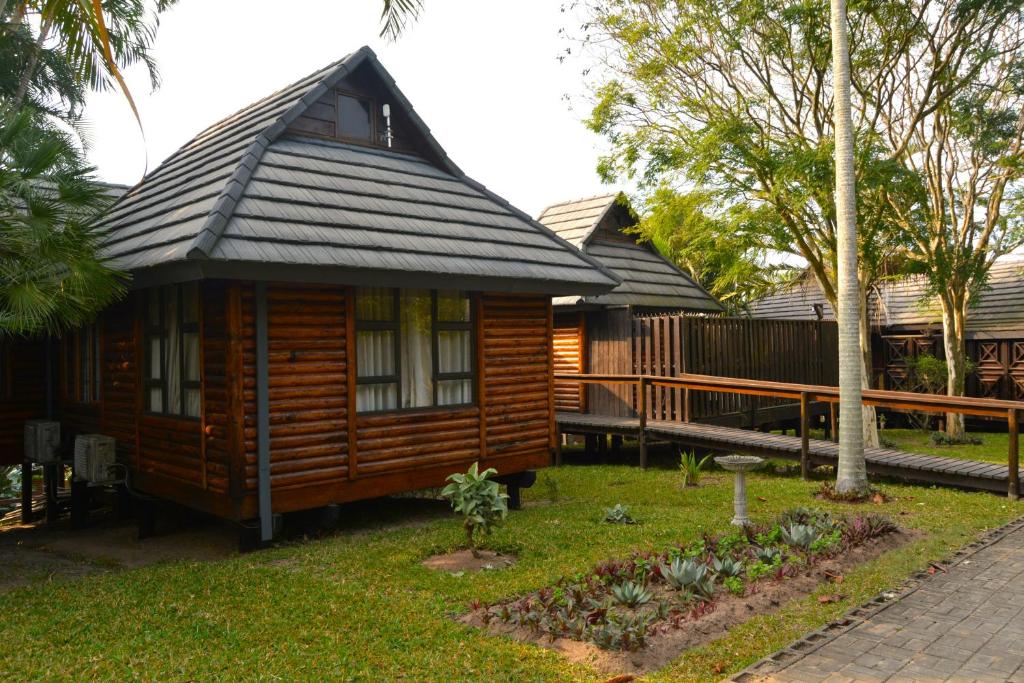 a small wooden cabin with a gambrel roof at Sodwana Bay Lodge House 34 in Sodwana Bay