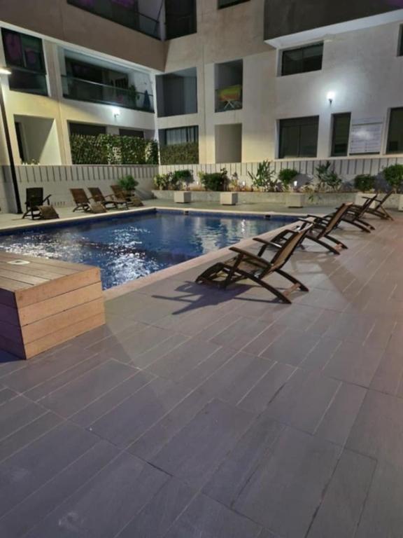 a row of lounge chairs sitting next to a swimming pool at Studio a Mohammedia pied dans l'eau in Mohammedia