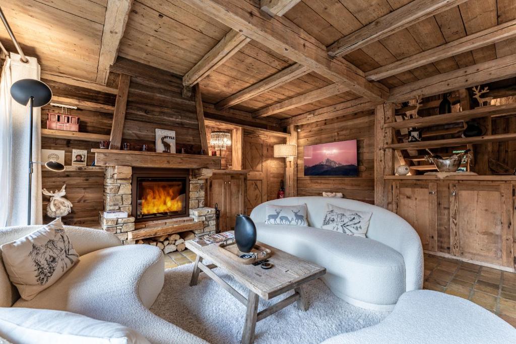 - un salon avec une cheminée dans une cabane en rondins dans l'établissement Chalet Mont d'Arbois Ski et Golf, à Megève