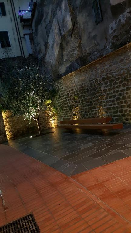 a stone wall with a bench in a courtyard at Appartamento Colletta in Ventimiglia