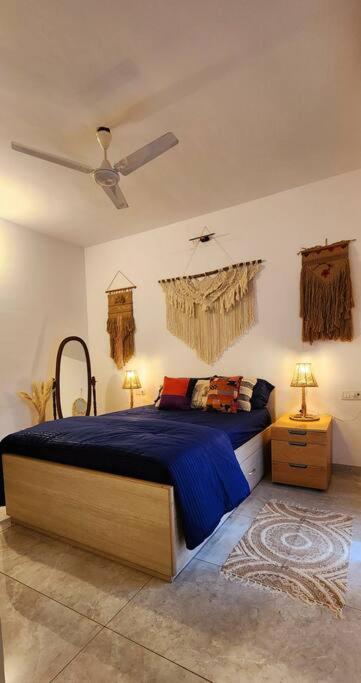 a bedroom with a bed and a ceiling fan at Boho 44 in Goa