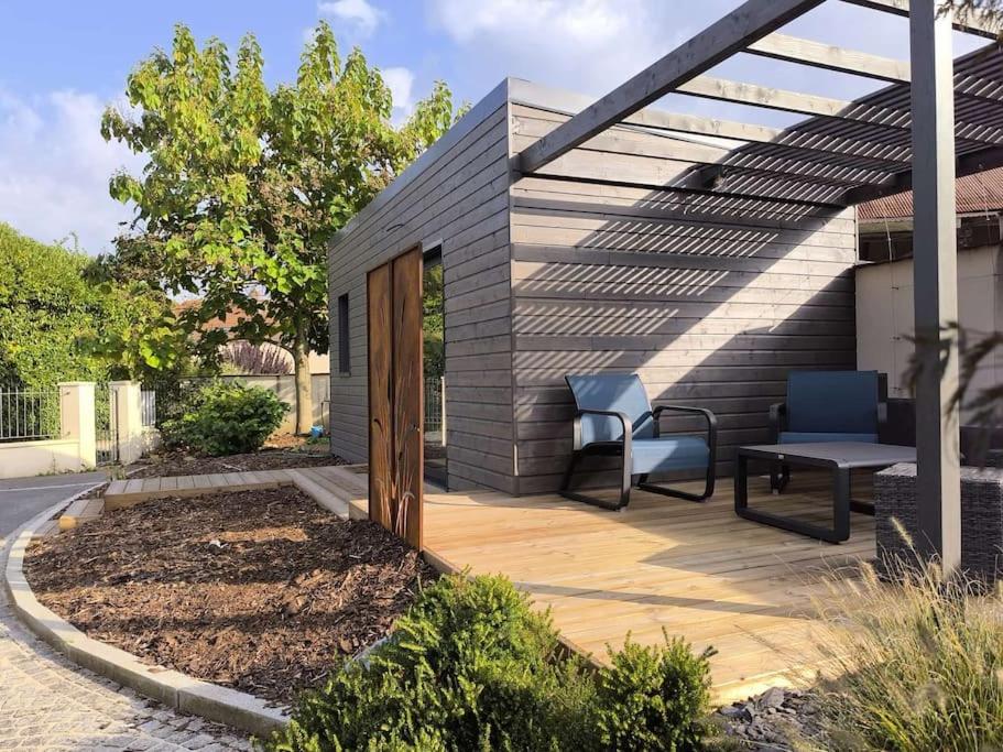 a patio with a chair and a bench on a deck at Entre Vignes et Forêt in Tauxières-Mutry