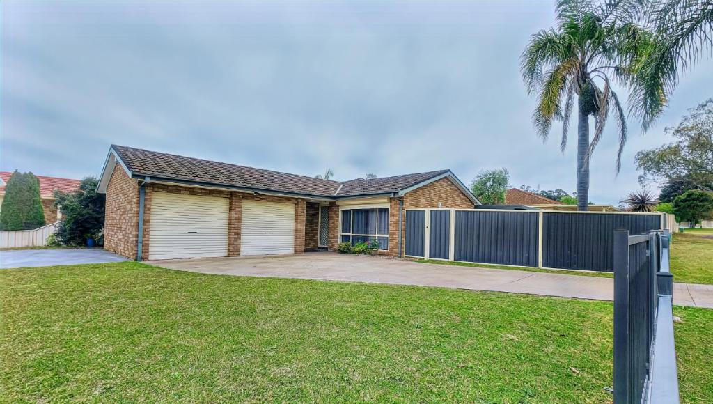 a house with a garage and a fence at Twin Palms @ The Basin in St Georges Basin