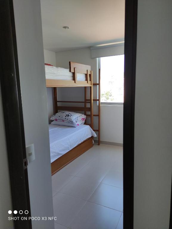 a room with two bunk beds and a window at Apartamento de tres habitaciones in Rodadero