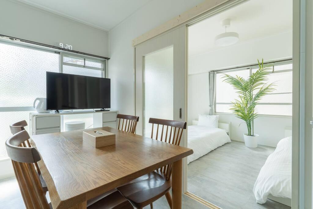 a living room with a dining room table with a television at 2 min from Nakatsu Station 5person apartment in Osaka