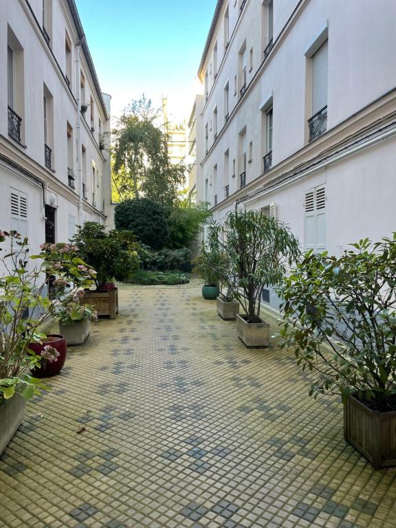 une cour vide avec des plantes en pot et des bâtiments dans l'établissement Appartement au rez de chaussée pres de gare de lyon, à Paris