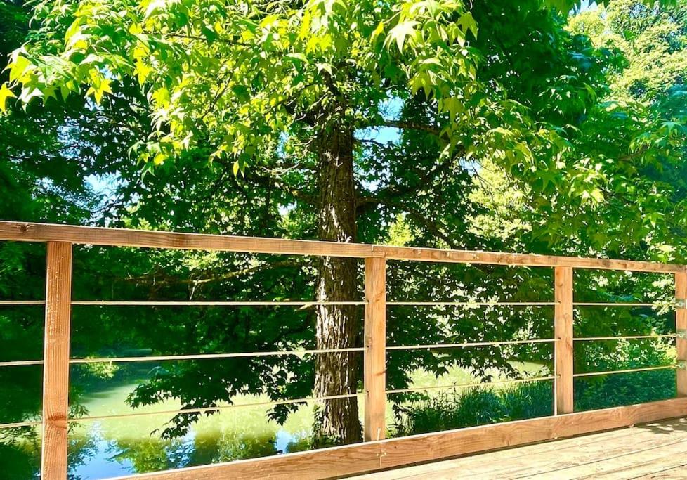 a wooden fence with a tree behind it at Domaine de Faye in Sauvigny-les-Bois