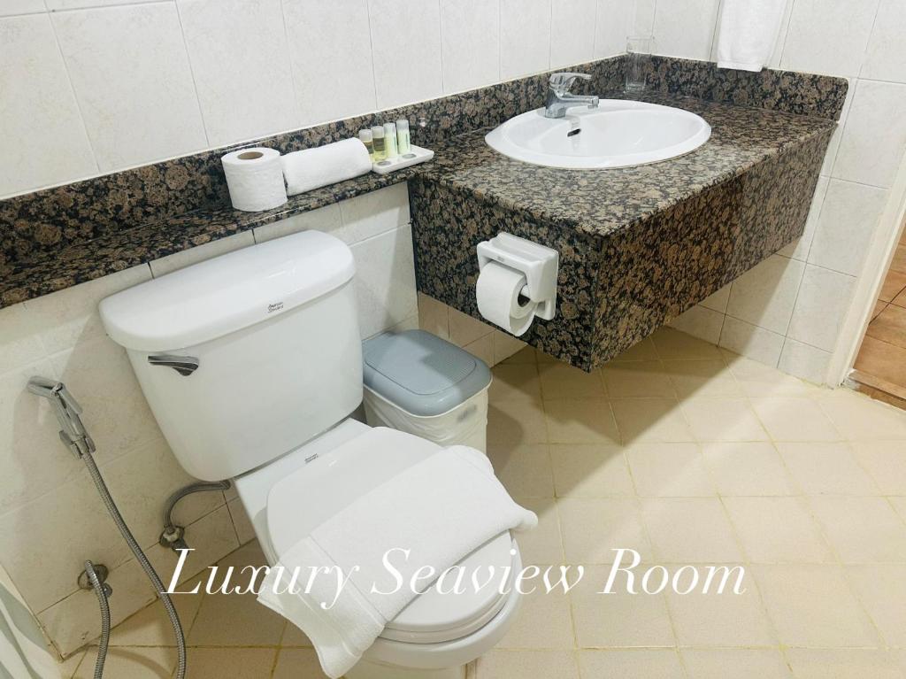 a bathroom with a white toilet and a sink at Surin Bay Inn in Surin Beach