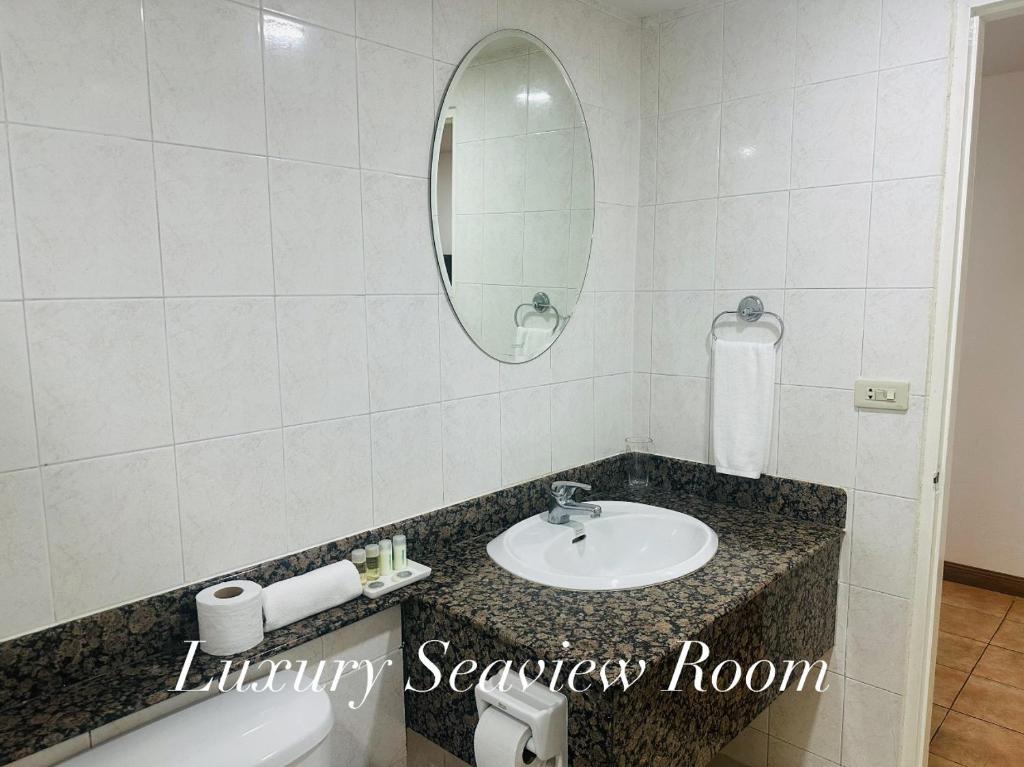 a bathroom with a sink and a mirror at Surin Bay Inn in Surin Beach