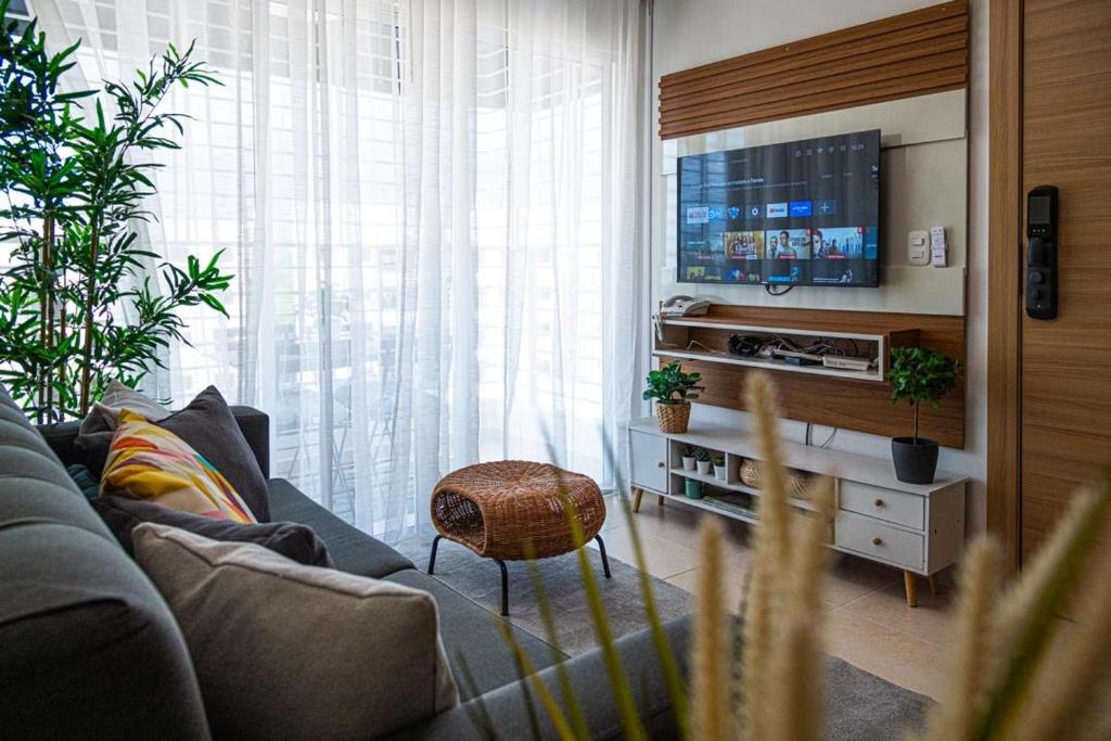 a living room with a couch and a flat screen tv at Europeo tropical in La Javilla