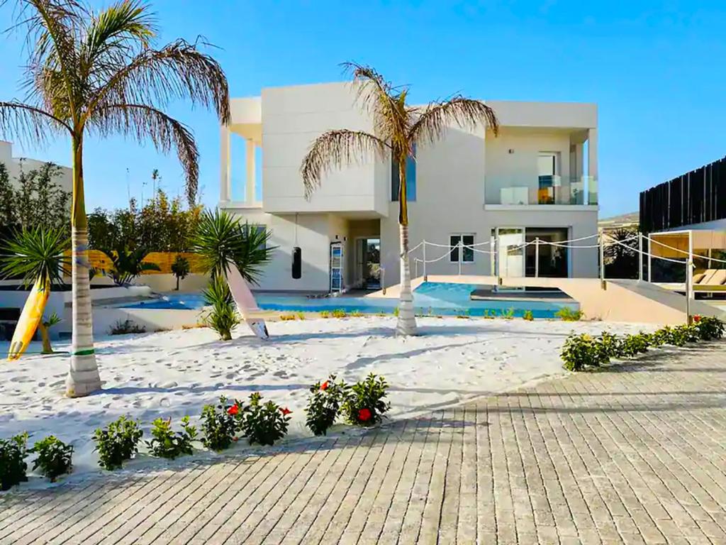 a house with palm trees and a swimming pool at Paraiso House in Callao Salvaje