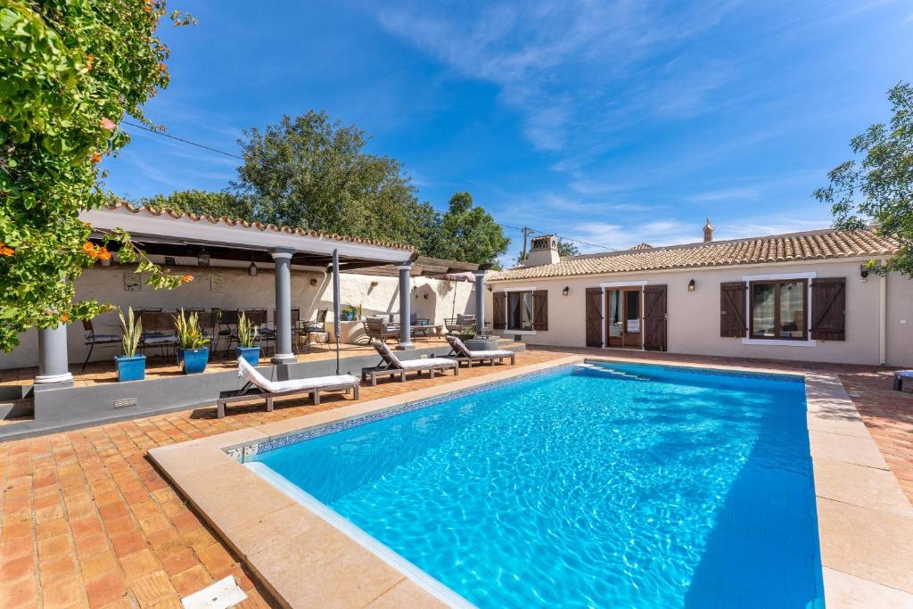 a swimming pool in the backyard of a house at The Quinta - 3 Bedroom ensuite Villa, Swimming Pool, Beautiful Gardens, water features and lake in Almancil