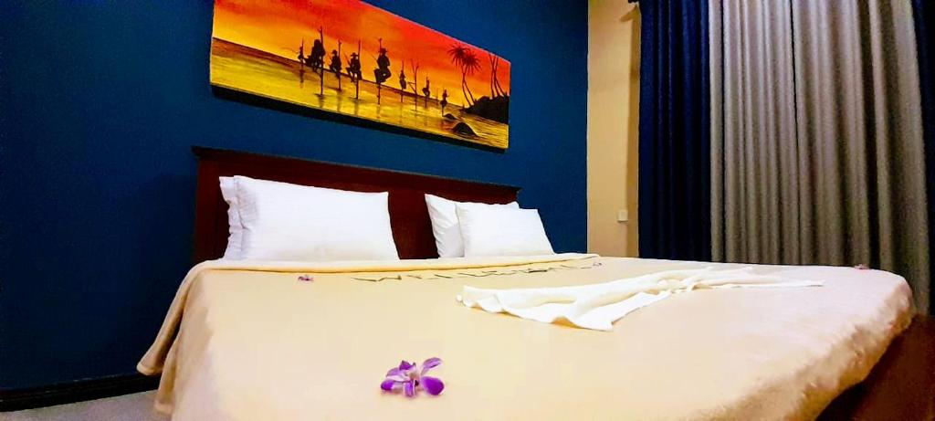 a bedroom with a bed with a purple flower on it at Ocean Gate Residence in Bentota