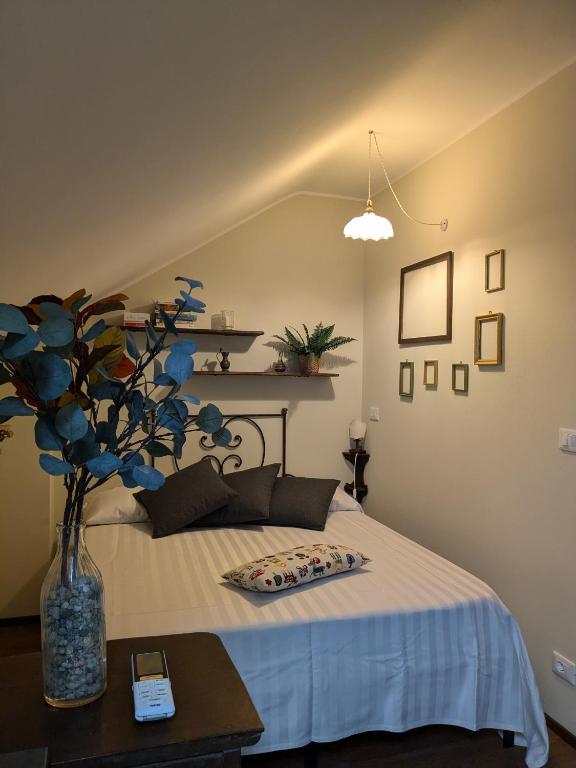 a bedroom with a bed with a vase of flowers at la nocciolina mansarda in centro in Cortemilia