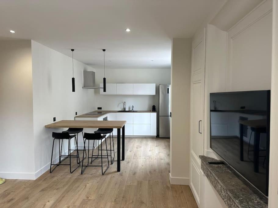 - une cuisine avec une table et des tabourets de bar dans l'établissement Appartement Brignais Centre en face du pont romain, à Brignais