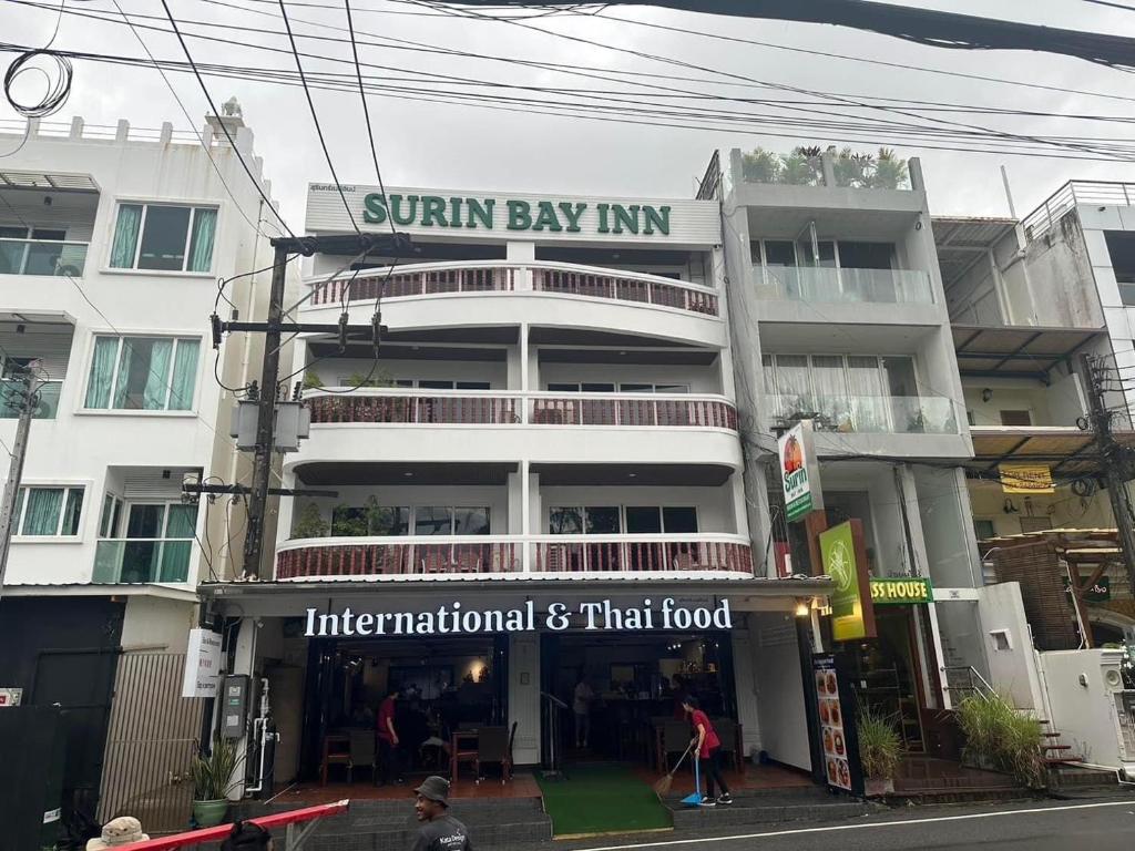 a building with a sign that reads sunbury bay inn at Surin Bay Inn in Surin Beach