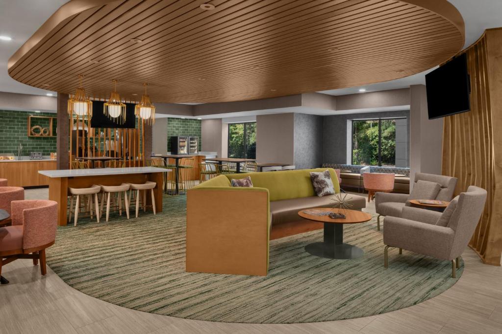 a lobby with a couch and chairs and a bar at SpringHill Suites Pinehurst Southern Pines in Pinehurst