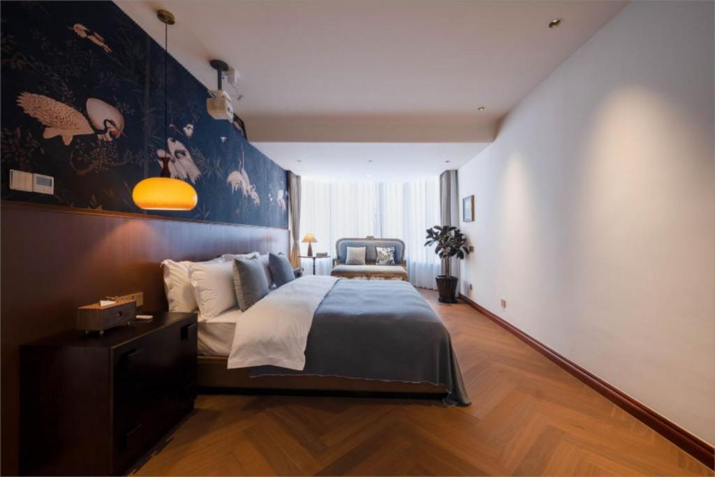 a bedroom with a large bed with a blue wall at Dali European Inn in Dali