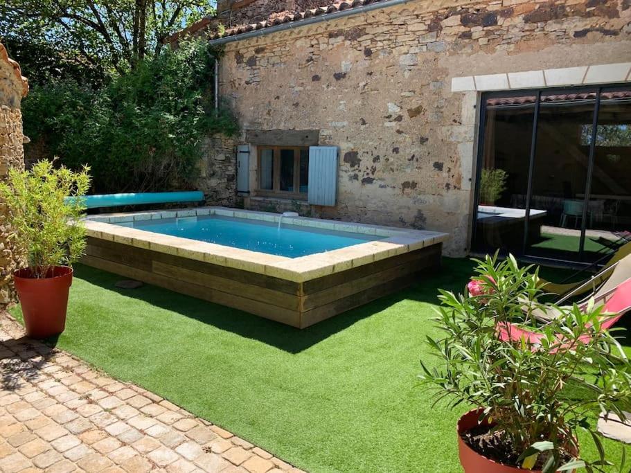 - une piscine dans une cour avec de l'herbe verte dans l'établissement maison avec piscine, à Blanquefort-sur-Briolance