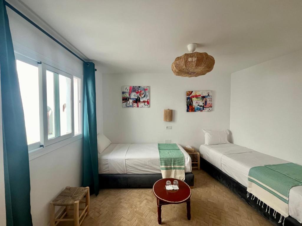 a bedroom with two beds and a window at RIAD OASIS D'ASILAH in Asilah