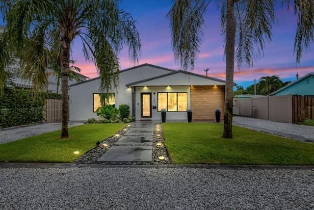 フォート・ローダーデールにあるLovely 2BR 2BA Modern Flat with Vibrant Backyardの前にヤシの木がある家