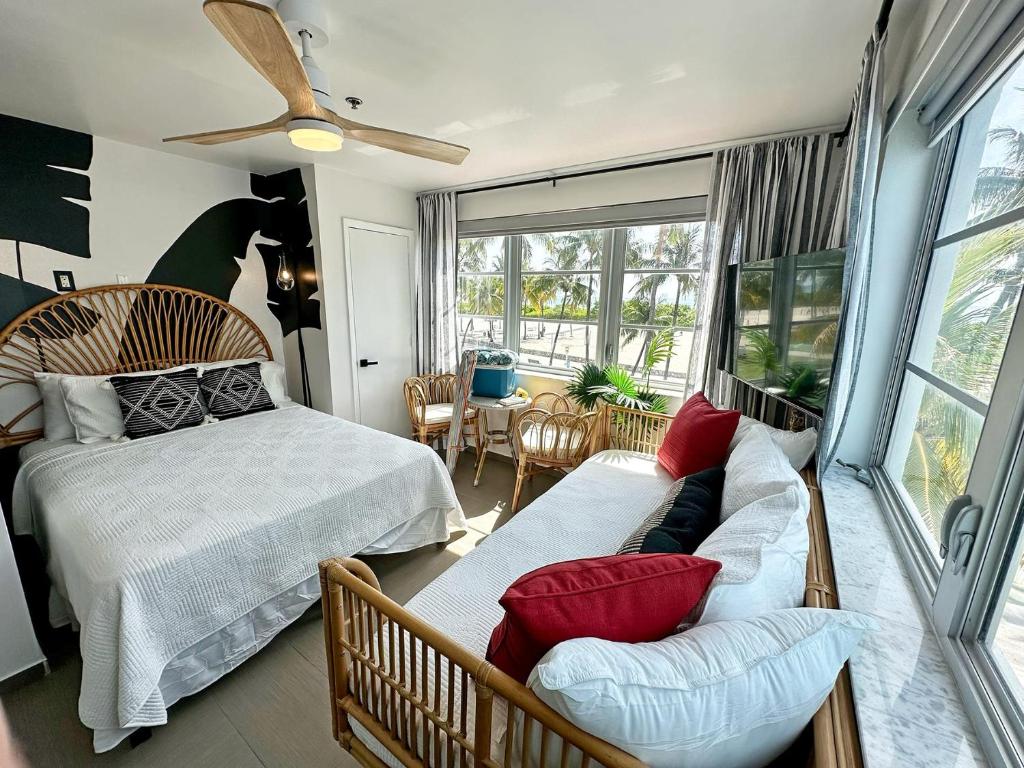 a bedroom with a bed and a couch and a window at Ocean Drive Oasis Beach Views South Beach Miami in Miami Beach