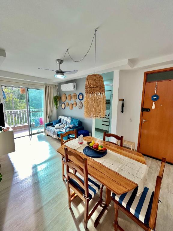 a living room with a wooden table and chairs at Apê Vumbora Pra Praia, todo climatizado, a 200 m da praia in Ilhéus