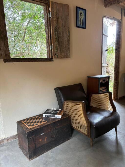 a living room with a leather chair and a table at Vila do Salitre - Refúgio Rupestre in Diamantina