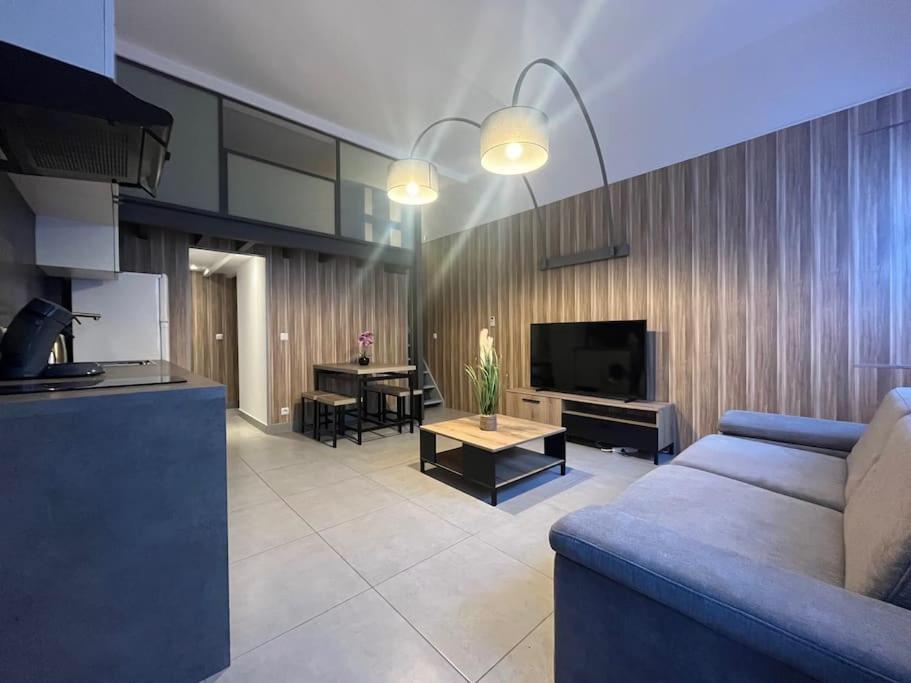 un salon avec un canapé bleu et une table dans l'établissement Cannes, Loft 6 couchages proche centre et plages, à Cannes