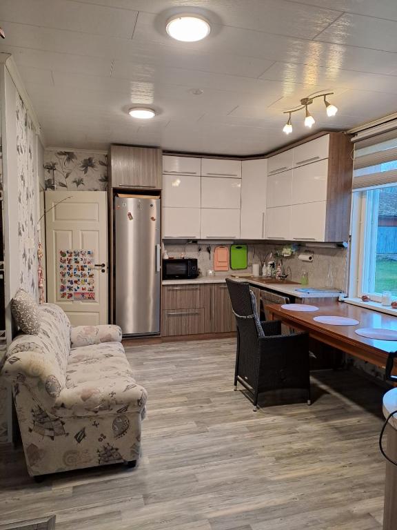 una cucina con mobili bianchi, tavolo e sedie di Villa Maarianvaara a Rikkaranta