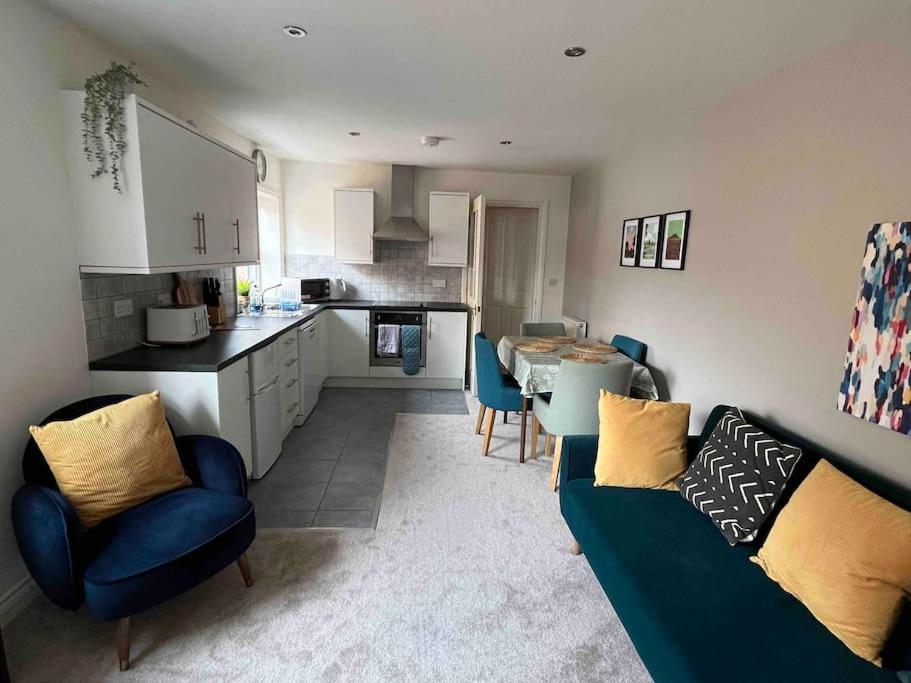 Una sala de estar con un sofá y una cocina. en Town centre apartment with parking, en Wallingford