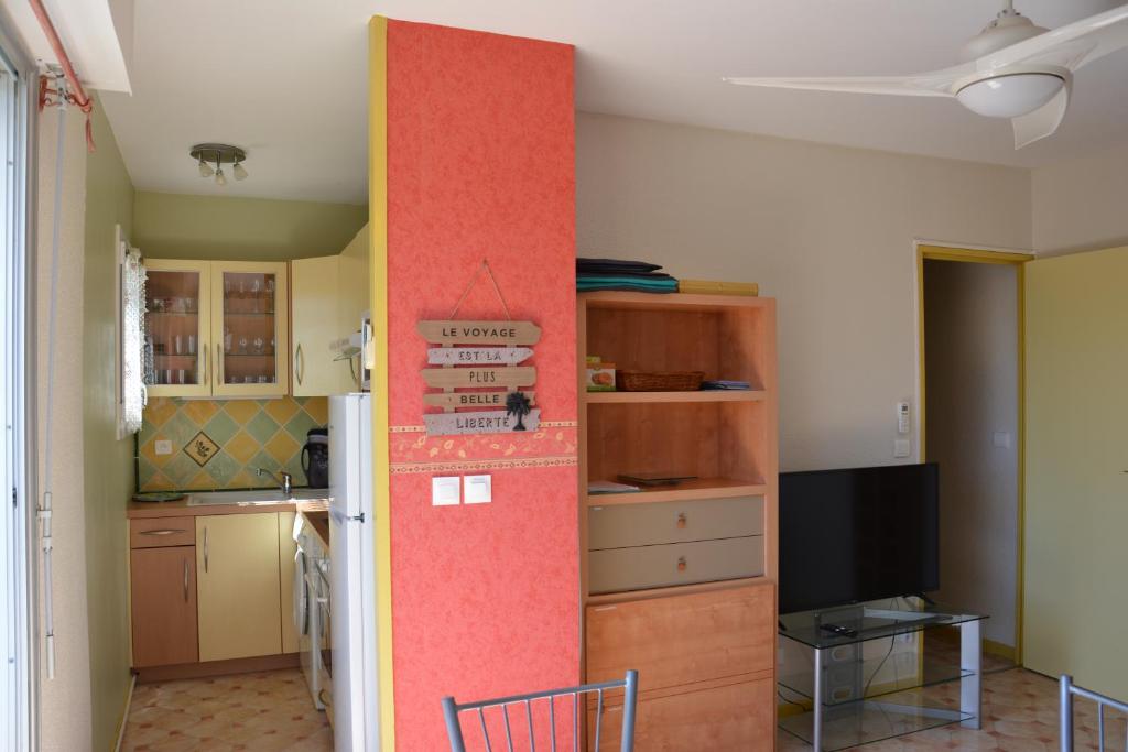 - une cuisine avec un mur rouge dans une pièce dans l'établissement les villageoises, au Barcarès