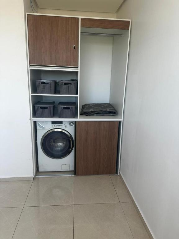 a laundry room with a washing machine in a closet at Aconchegante estilo in Pato Branco