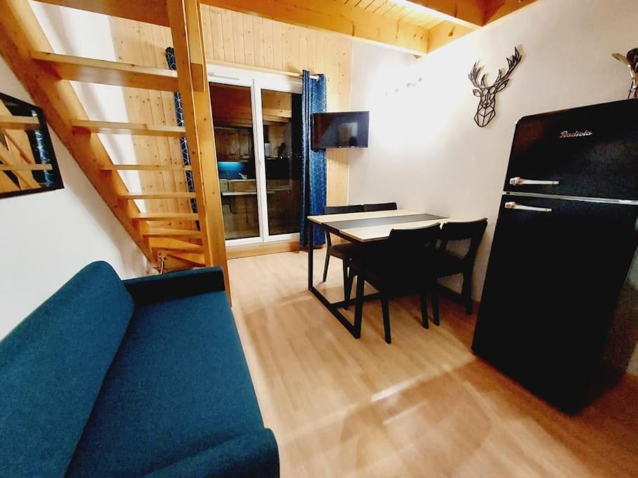 un salon avec un canapé bleu et une table dans l'établissement LE COSY à Aime La Plagne, à Aime La Plagne