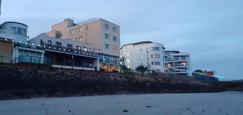 a group of buildings on the shore of a beach at Marina Metro Hotel in Saint Helier Jersey