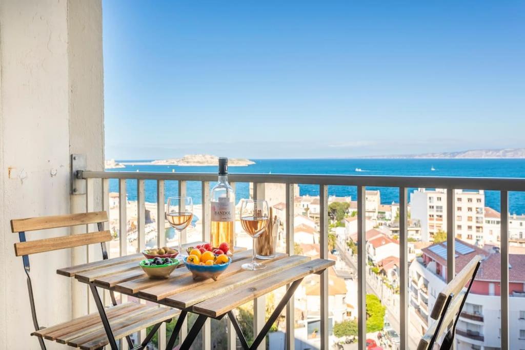 - une table avec des verres de vin et des fruits sur le balcon dans l'établissement Dream Ocean View with Balcony Close to Beach, à Marseille