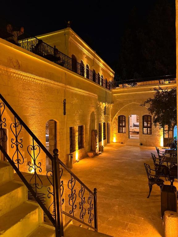 a building with a staircase leading to a courtyard at night at Cleopatra Antique Hotel in Urfa