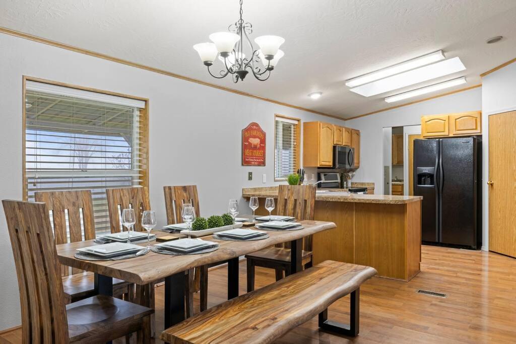 a kitchen with a wooden table with chairs and a refrigerator at Acres of Private & Spacious Country Escape! in Kennewick