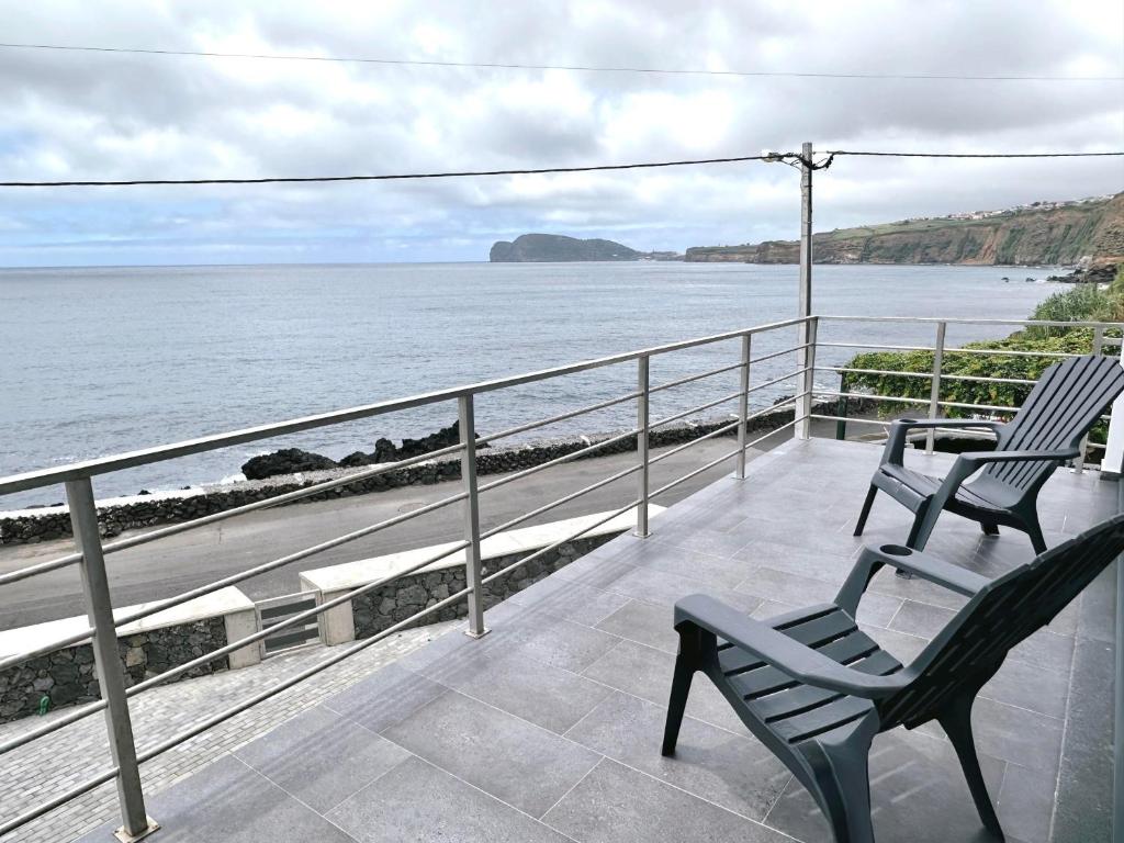 two chairs sitting on a balcony looking at the ocean at Miramar in Angra do Heroísmo