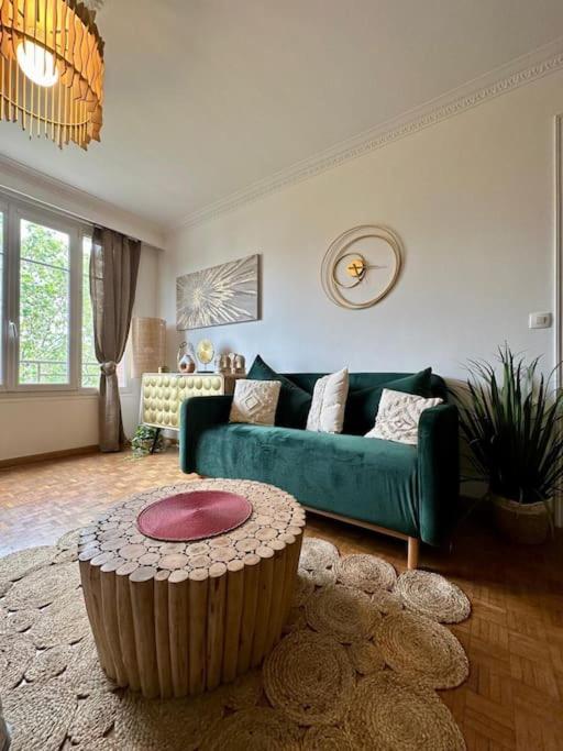 - un salon avec un canapé vert et une table basse dans l'établissement Appartement Standing Paris, à Paris