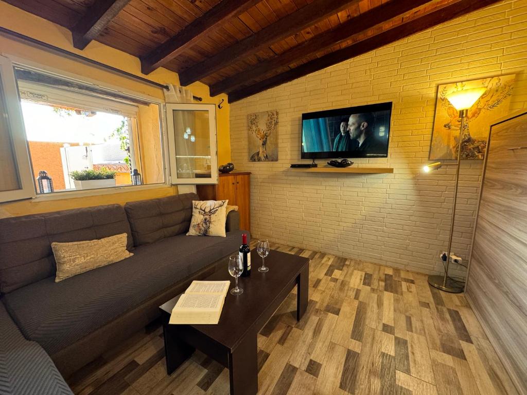 a living room with a couch and a tv on a wall at La Casita de Claudia in Aguatona