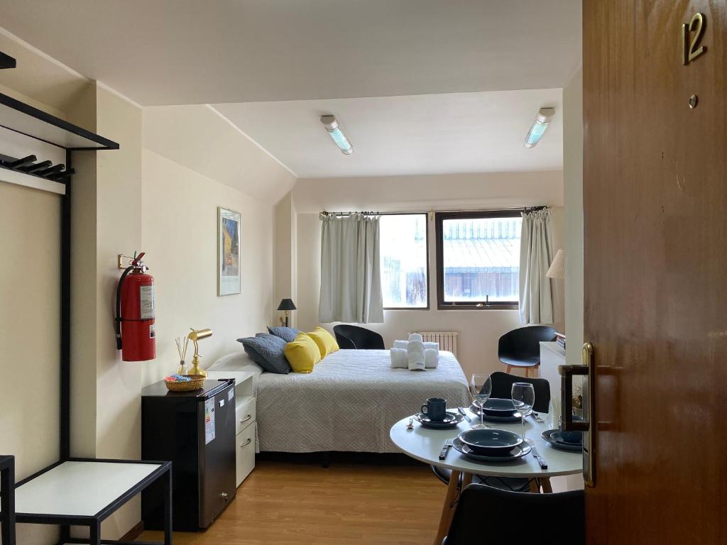 a bedroom with a bed and a table in it at Nido del Cormorán in Ushuaia