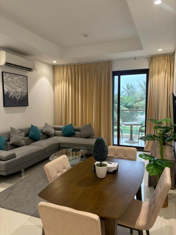a living room with a table and a couch at Hawana VIP Appartment in Ma‘mūrah