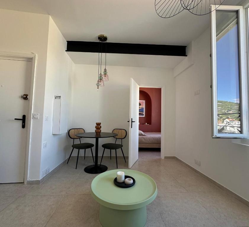 a living room with a table and chairs in it at Studio Cocon - Entièrement rénové - 4 couchages - 600m de la Gare de Cannes in Cannes