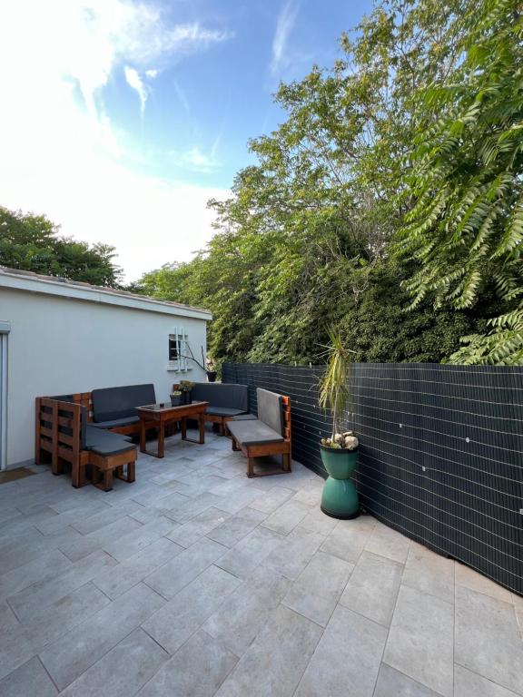 d'une terrasse avec des chaises, des tables et une clôture. dans l'établissement Grand appartement avec terrasse centre ville Arles, à Arles